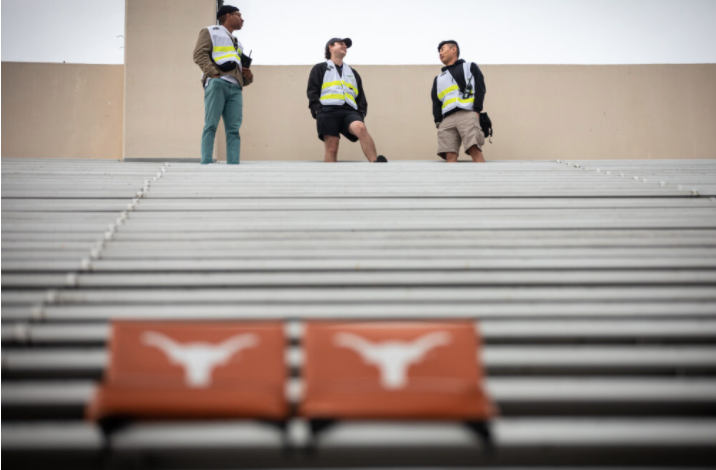 Event personnel preparing for a day of drone technology experimentation at the DKR Texas memorial stadium.