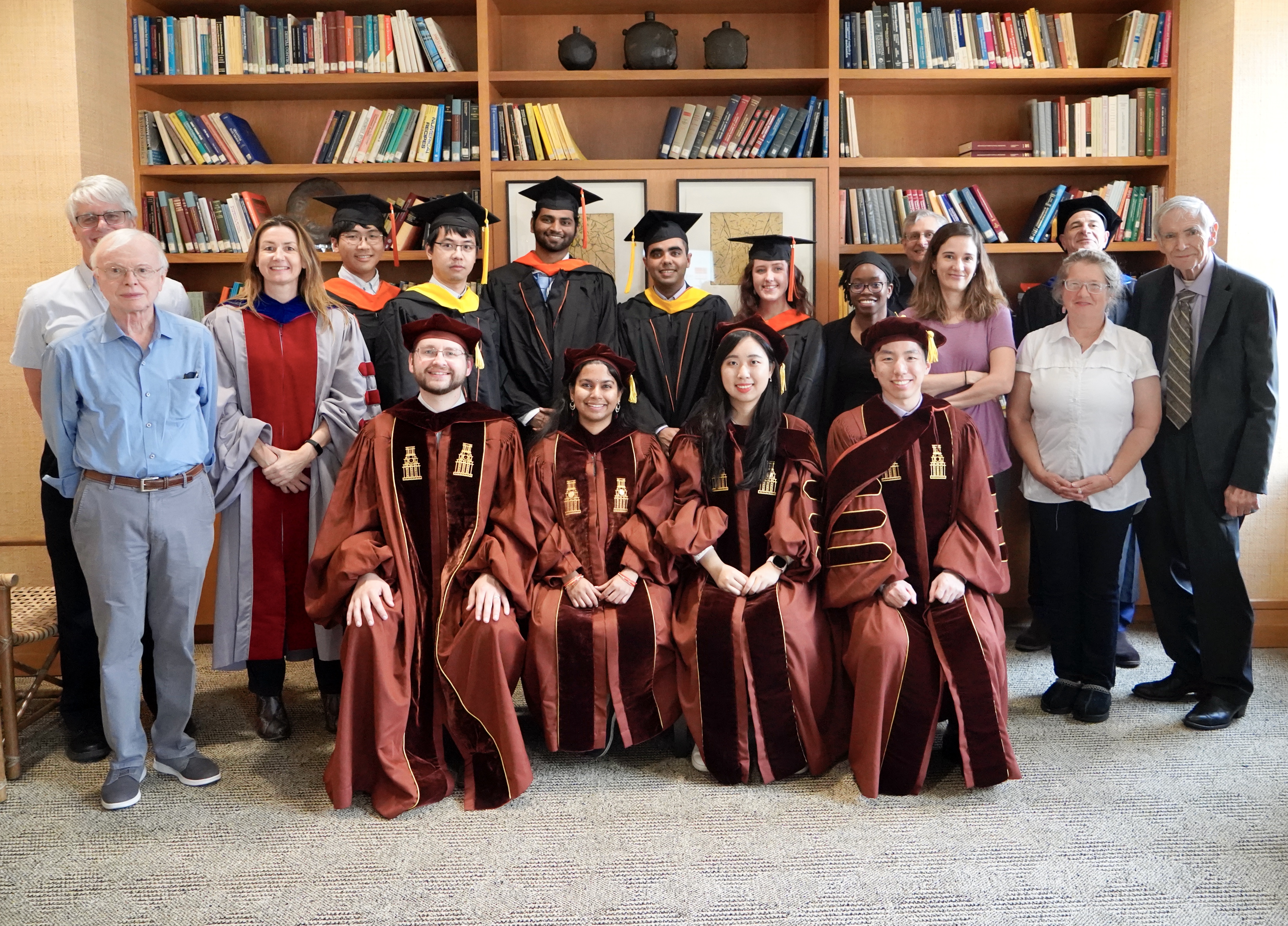 Graduates and their advisors celebrate at a post-commencement reception.